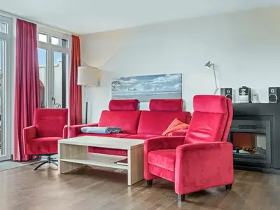 Wohnzimmer mit Couch, Couchtisch, Sessel und Kamin