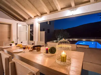 voll ausgestattete Kueche mit Essbereich und WC mit Blick auf den Pool Bereich