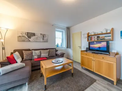 Wohnbereich mit Sofa, Couchtisch und TV