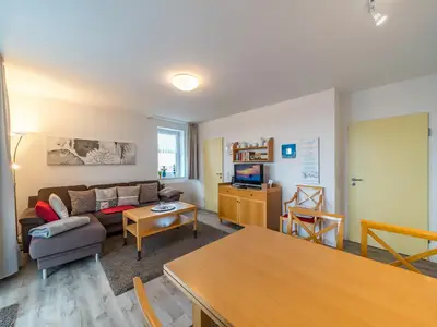Wohnbereich mit Sofa, Couchtisch und Esstisch