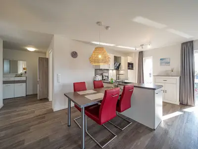 Wohn-Essbereich mit Esstisch, Sitzgelegenheit und Küchenzeile