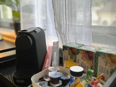 Kaffeemaschine und Kapseln und Tee und Zucker