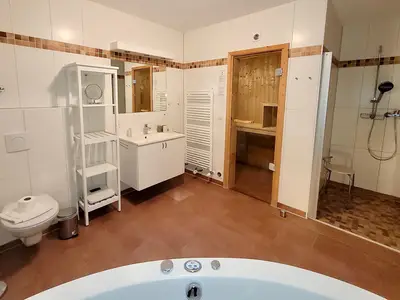 Badezimmer mit Badewanne und Saunabereich
