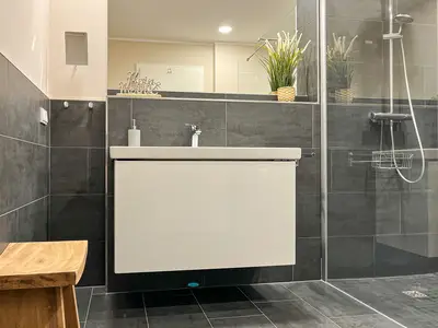 Badezimmer mit Waschbecken und Sitzgelegenheit