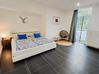 Großes Schlafzimmer mit Doppelbett, eigenem Bad und Balkon