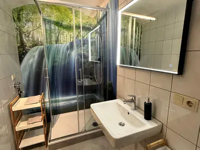 Badezimmer mit Dusche, Waschbecken und WC