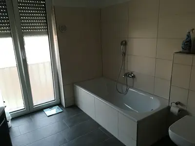 Das Badezimmer mit Tageslicht, Badewanne und Dusche