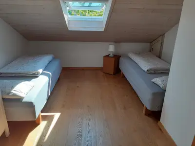 Schlafzimmer 2 mit zwei Einzelbetten und Gitterbett