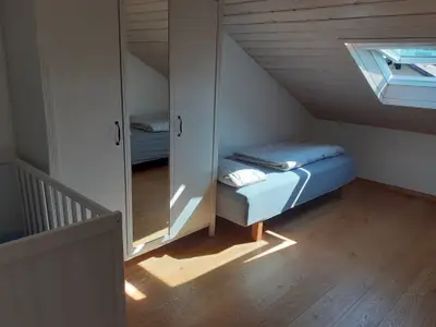 Schlafzimmer 2 mit zwei Einzelbetten und Gitterbett