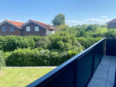 Blick vom Balkon auf den Deich und in den Garten