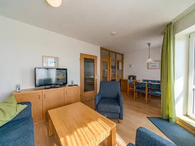 Wohn-Essbereich mit Couch und Flatscreen-TV