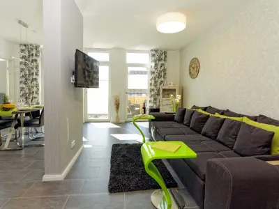 Flatscreen-TV mit Couch im Wohn-Essbereich