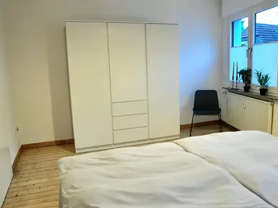 Schlafzimmer mit Fenster und großem Kleiderschrank