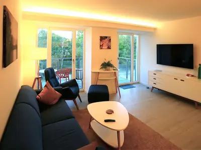 Wohn/Essbereich: Sofa, Sessel, TV, Zugang zum Balkon