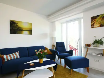 Wohn/Essbereich: Sofa, Sessel, TV, Zugang zum Balkon