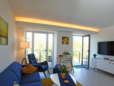 Wohn/Essbereich: Sofa, Sessel, TV, Zugang zum Balkon