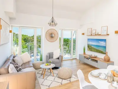 Wohnzimmer: Sofa, Smart-TV, Zugang zum Balkon