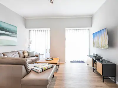 Wohnzimmer: Sofa, TV, Zugang zu den 2 Terrassen