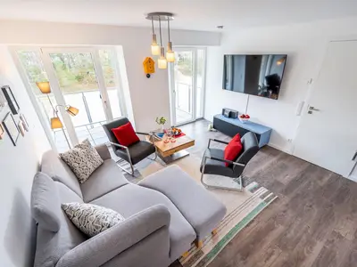 Wohn/Essbereich: Sofa, Flachbildfernseher, Zugang zum Balkon