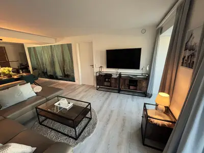 Wohn/Essbereich: Sofa, TV, Zugang zum Balkon