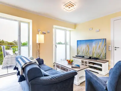Wohn- und Essbereich: Sofa, TV, Blue Ray Player, Safe, Zugang zum Balkon