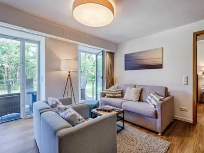 Wohnzimmer: Schlafcouch für 2 Pers., Smart-TV 55 Zoll, Essbereich, Zugang zum Balkon