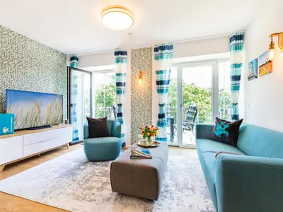 Wohn-/Essbereich: Sitzgruppe mit Couch und Sessel, Smart-TV, Zugang zum Balkon, Esstisch mit 5 Stühlen