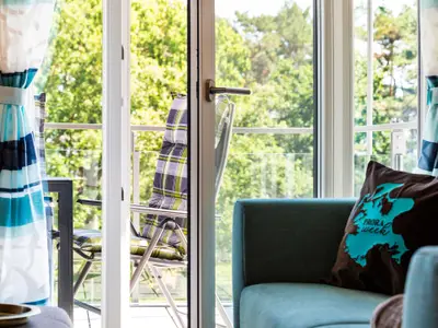 Wohn-/Essbereich: Sitzgruppe mit Couch und Sessel, Smart-TV, Zugang zum Balkon, Esstisch mit 5 Stühlen