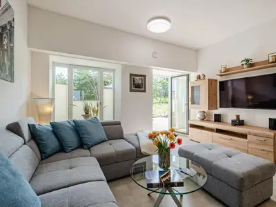 Wohnzimmer: Schlafsofa und Sessel, TV, Essbereich, Zugang zur Terrasse