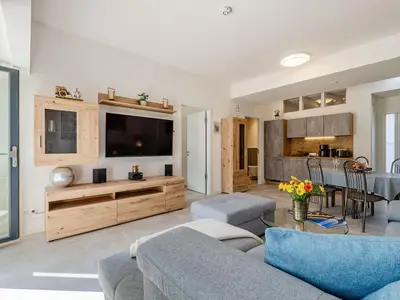 Wohnzimmer: Schlafsofa und Sessel, TV, Essbereich, Zugang zur Terrasse