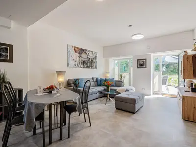 Wohnzimmer: Schlafsofa und Sessel, TV, Essbereich, Zugang zur Terrasse