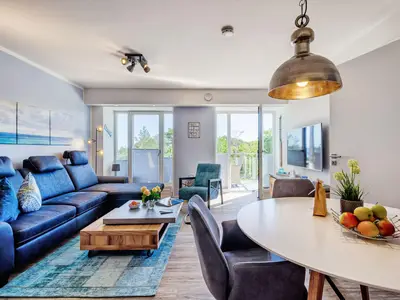 Wohnzimmer: Sofa, TV, Essbereich, Zugang zum Balkon