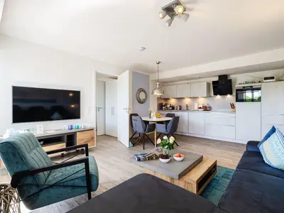 Wohnzimmer: Sofa, TV, Essbereich, Zugang zum Balkon