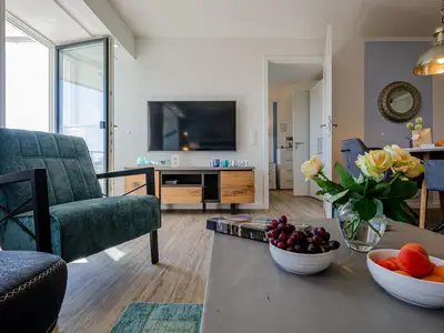 Wohnzimmer: Sofa, TV, Essbereich, Zugang zum Balkon