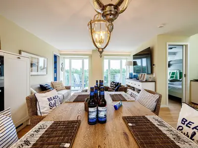 Wohnbereich/Essbereich: Sofa, TV, Treppenaufgang zur Dachterrasse, Zugang zum Balkon