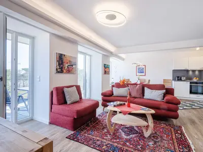 Wohnzimmer: Schlafsofa und Sessel, TV, Essbereich, Zugang zum Balkon