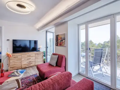 Wohnzimmer: Schlafsofa und Sessel, TV, Essbereich, Zugang zum Balkon