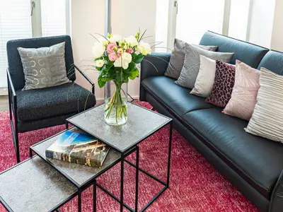 Wohnbereich/Essbereich: Sofa, TV, Beschattungs-Plissess, Treppenaufgang zur Dachterrasse, Zugang zum Balkon