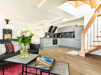 Wohnbereich/Essbereich: Sofa, TV, Beschattungs-Plissess, Treppenaufgang zur Dachterrasse, Zugang zum Balkon