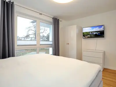 erstes Schlafzimmer mit Kleiderschrank und TV