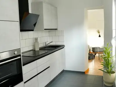 Die helle und moderne Küche mit Zugang zum Wohnraum