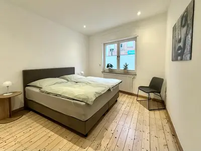 helles Schlafzimmer mit gemütlichem Boxspringbett