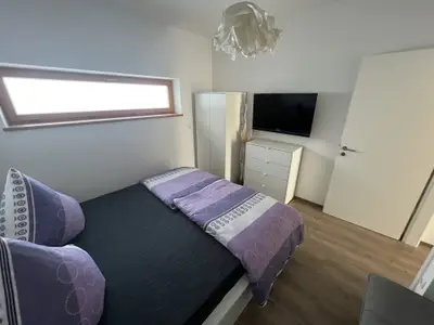 Schlafzimmer mit Flachbild TV und Schrank