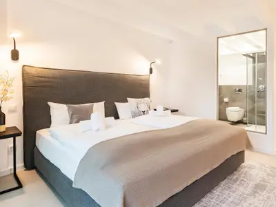 Schlafzimmer 1: Doppelbett (180x200), Schrank, Smart-TV, Verdunkelungsmöglichkeiten, Zugang zum Balkon (Seeseite)