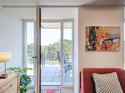 Wohnzimmer: Schlafsofa und Sessel, TV, Essbereich, Zugang zum Balkon