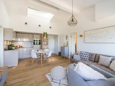 Wohnzimmer: Sofa, Smart-TV, Zugang zum Balkon