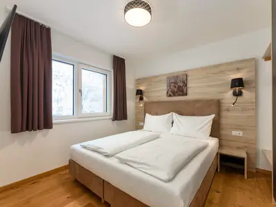 Schlafzimmer mit Doppelbett und TV