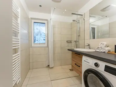 Badezimmer mit Dusche und Waschmaschine