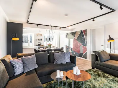 Wohn-/Essbereich: Couchgruppe mit Tisch, Smart-TV, Essbereich, Zugang zum Balkon mit Tisch und Stühlen (Seeseite), Sonne