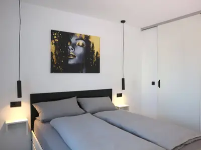 Bequemes Doppelbett und geschlossene Schiebetür zum Wohnbereich